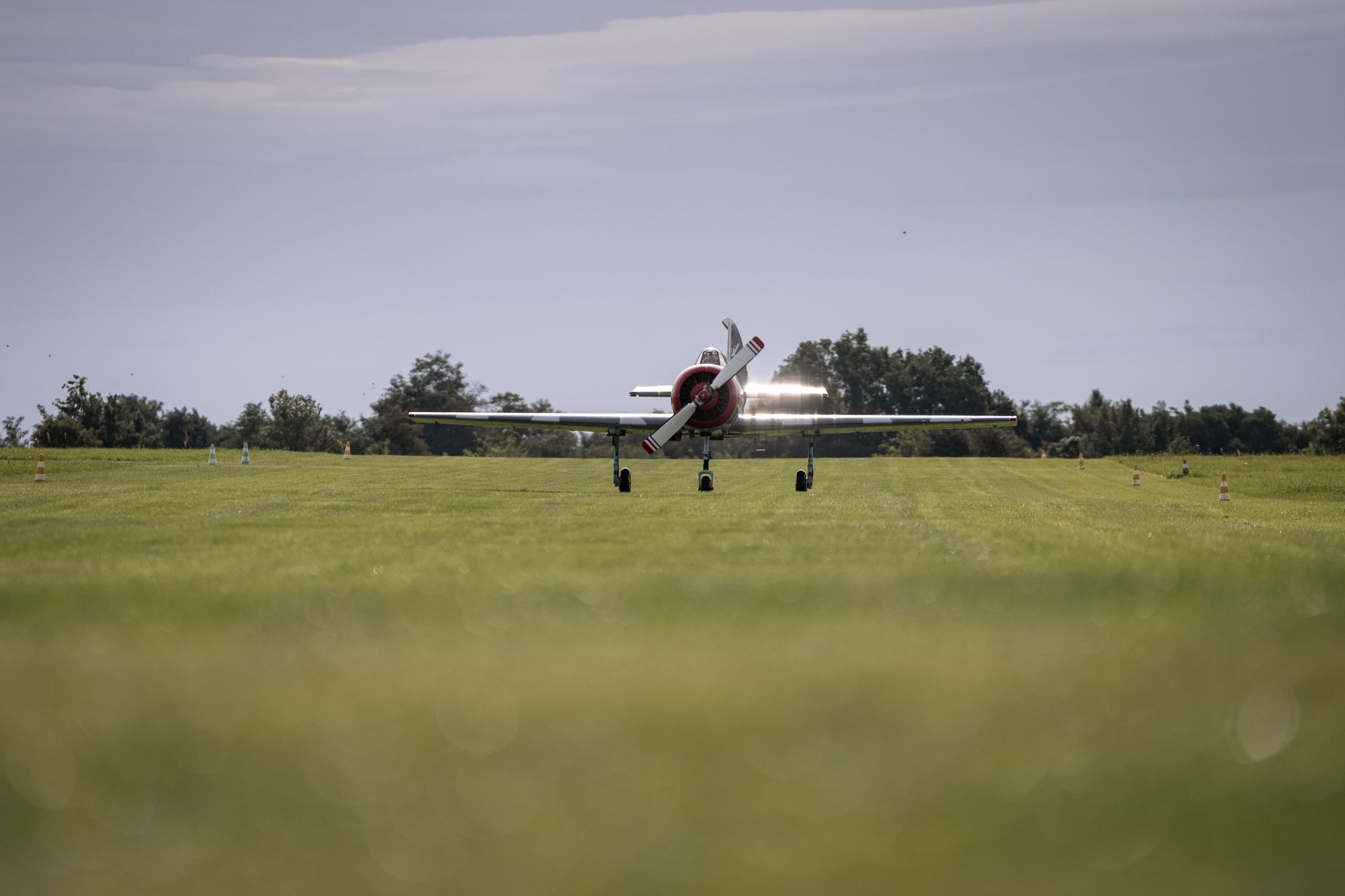 Kleines Flugzeug steht auf grünem Gras vor Start
