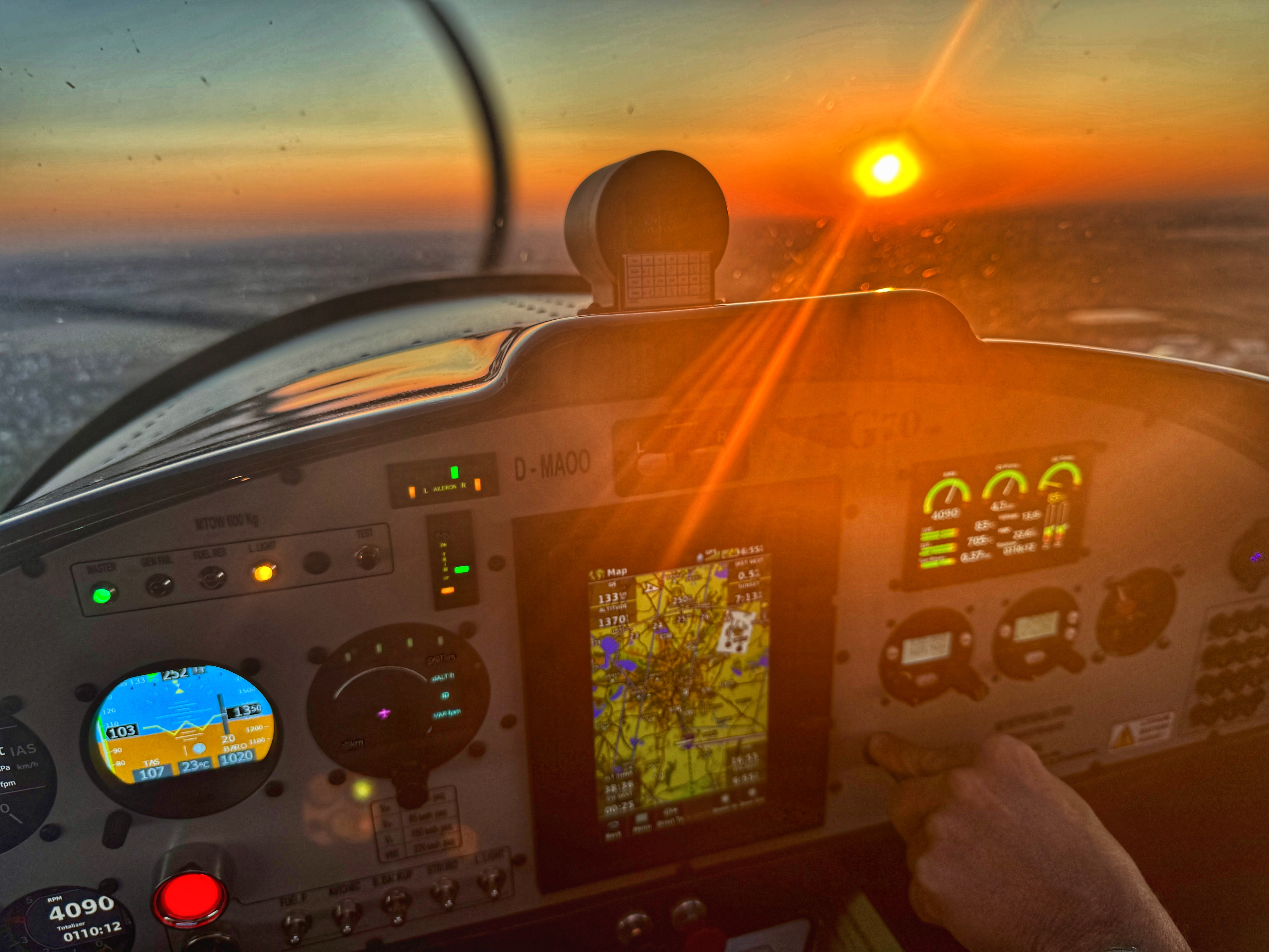 Cockpit eines Flugzeugs während des Sonnenuntergangs Blick auf das Cockpit eines Flugzeugs bei Sonnenuntergang, mit beleuchtetem Instrumentenpanel und GPS-Anzeige.