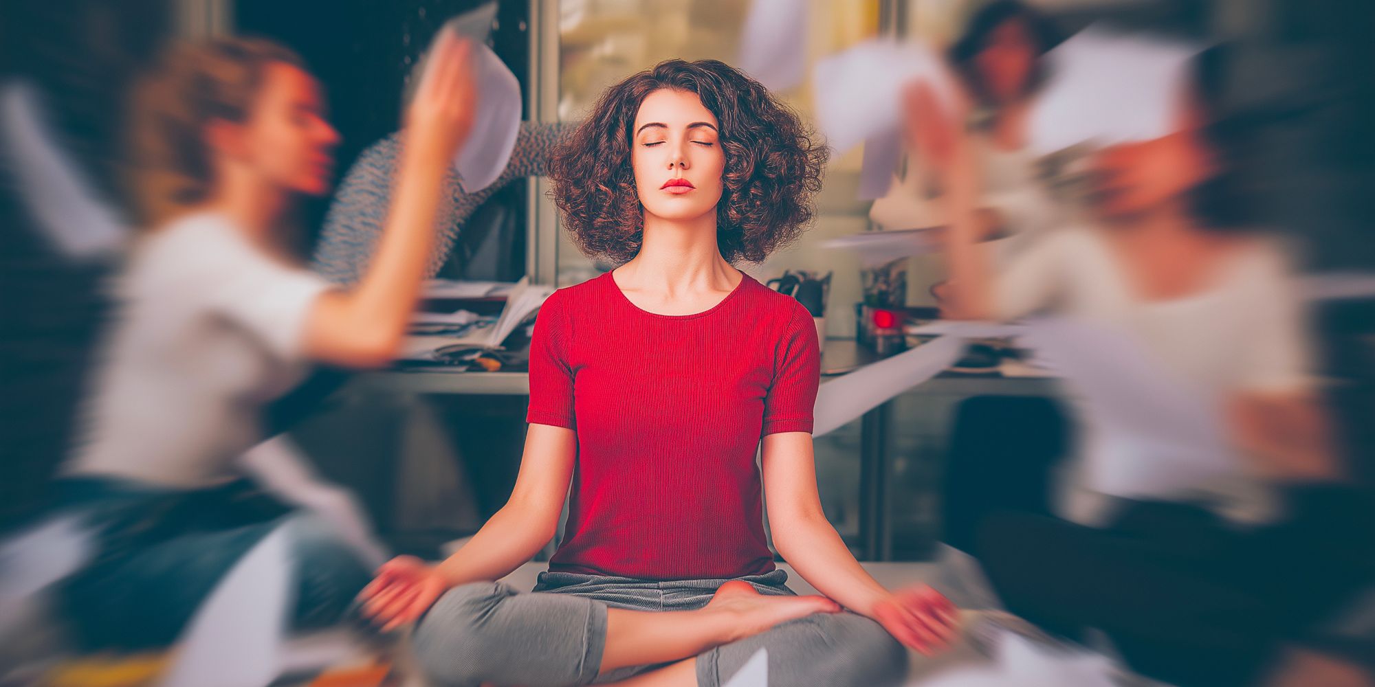 Frau in rotem Shirt meditiert entspannt im Büro
