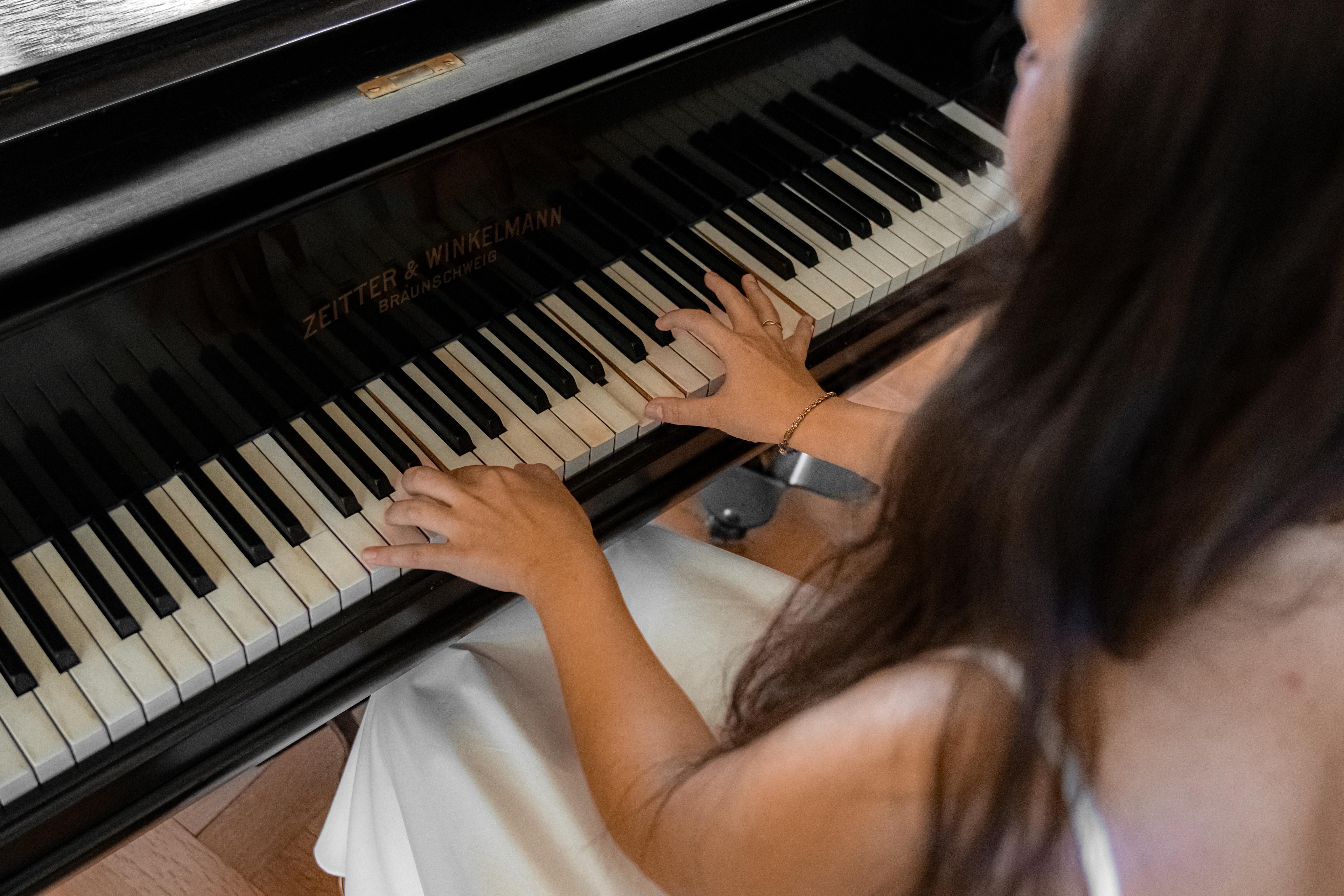 Nahaufnahme einer Frau, die auf einem Zeitter & Winkelmann Klavier spielt
